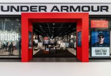 Under Armour Joins US Cotton Trust Protocol for Traceability Under Armour storefront with a bright red entrance in a mall, shoppers browsing athletic apparel inside.