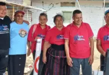 Target supplier pays Guatemalan garment workers $6m in back pay Group of six people posing together outdoors, some wearing red polo shirts with logos, others in casual clothes; a brick building in the background.