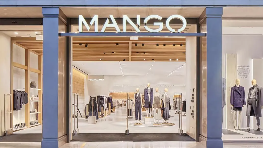 Mango storefront with mannequins in stylish outfits inside a bright, modern shop.