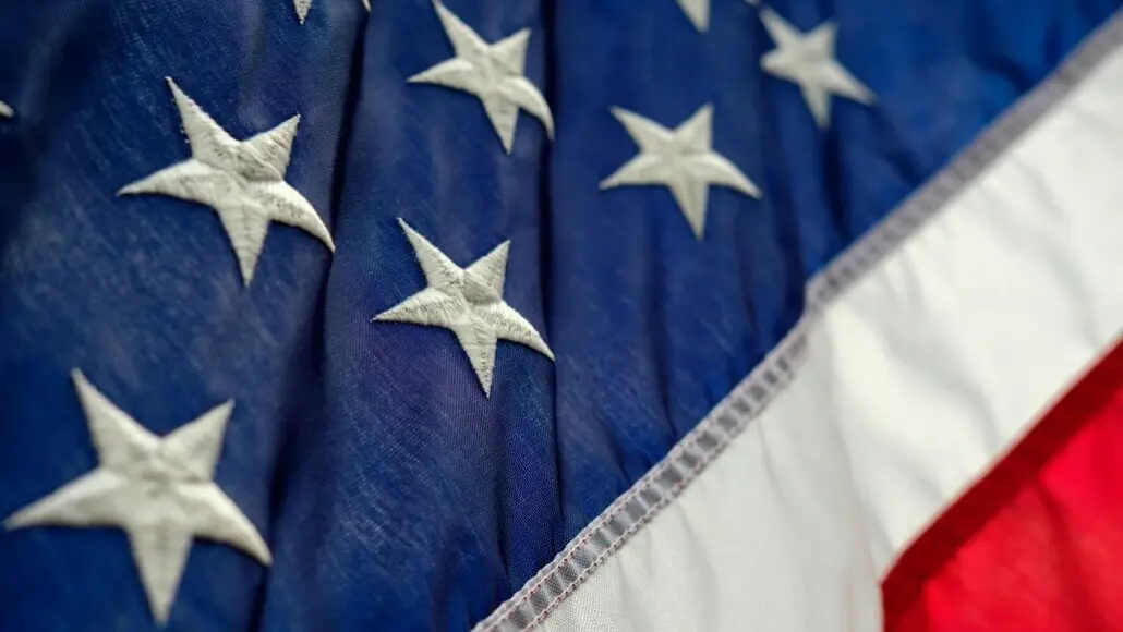 Close-up of white stars on the blue canton of the American flag with red and white stripes visible.