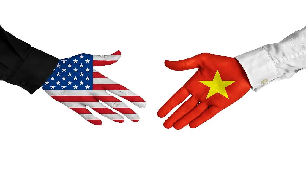 Handshake between a US-flag hand and a Vietnam-flag hand, symbolizing US–Vietnam relations or diplomacy.