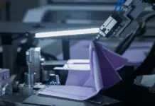CreateMe, Avalo and Laguna Launch Seed to System for Apparel Automated robotic arm handling purple fabric on a manufacturing machine.