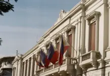 Philippines Pushes PTF Law Compliance to Boost Local Textiles White neoclassical building with ornate balconies and several hanging flags against a clear sky