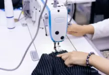 Sanko Outlines Plan for Comprehensive Textile Manufacturing Facility in Bangladesh Person sewing dark pinstriped fabric with an industrial sewing machine.