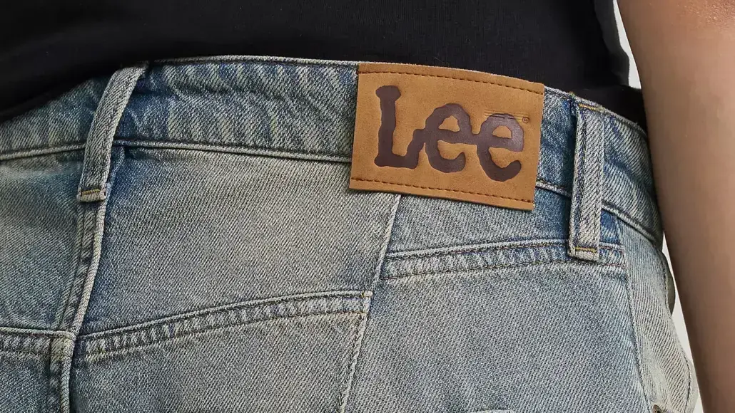 Close-up of blue denim jeans waistband with brown Lee brand patch