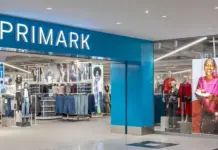 Primark Enhances Product Quality and Reduces Prices for UK Shoppers Front of a Primark store with a bright blue sign and visible clothing racks inside the entrance.