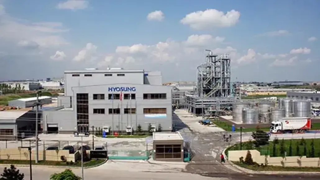 Industrial complex with a Hyosung facility, large building and processing tanks in a chemical plant yard.