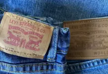 Levi Strauss Raises FY26 Forecast Following Strong Q2 Performance Back view of blue jeans with brown Levi's leather patch showing 'Levi Strauss & Co' text and horse motif on the left pocket area.
