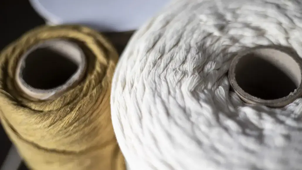 Close-up of two large yarn skeins, white and brown, showing textured fibers.