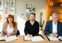 H&M Group, IndustriALL, and IF Metall Strengthen Global Framework Agreement for Supply Chain Standards Three professionals sign documents at a conference table in a bright office setting.