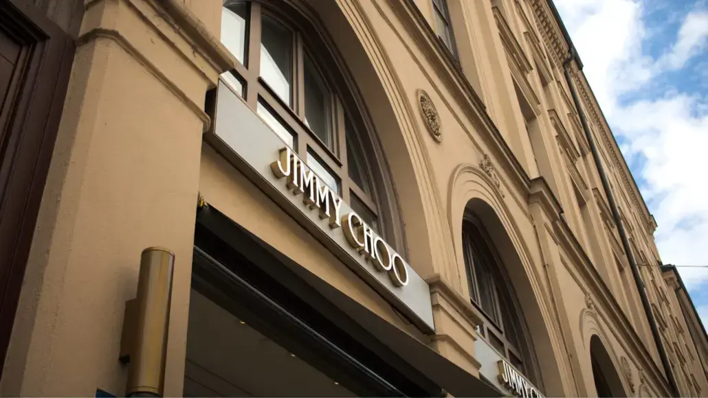 Jimmy Choo storefront on a beige historic building with arched windows and a large sign above the entrance.
