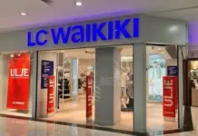 Turkish Garment Companies Eye Syria as LC Waikiki Starts Aleppo Production LC Waikiki storefront in a mall with a bright blue sign and open entrance, mannequins and clothing visible inside.