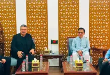 Sanko Announces $300 Million Investment for Integrated Textile Facility in Bangladesh Four men in a formal meeting seated on sofas with glass tables and water bottles, in a room with decorative wooden partitions.