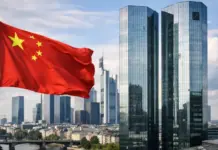 Deutsche Bank Appointed as RMB Clearing Bank in Frankfurt to Bolster Trade Chinese flag waving on a pole with a modern glass skyscrapers in the city skyline