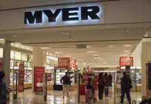 Myer Group Announces FY26 Financial Results and Strategic Progress Entrance to a Myer department store with the large MYER sign overhead and shoppers walking through the aisles, red sale signs visible throughout the store.