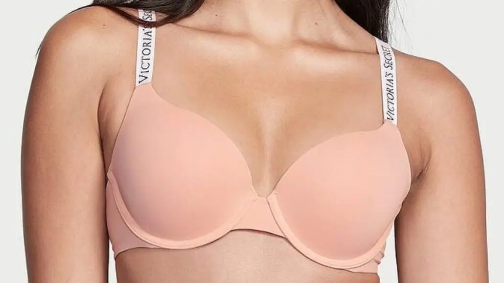 Peach-colored underwire bra on a model with branded Victoria's Secret straps visible on the shoulders