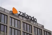 Zalando Launches Recycled Cotton T-Shirt Collection with RE&UP’s Next-Gen Fibre Zalando logo on the top of a modern glass-front office building against a gray sky.