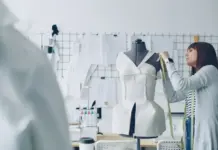 Lectra Launches Apogy – A Cloud-Based AI Platform Redefining Fashion Product Development Designer in a studio takes measurements on a white dress form using a tape measure.