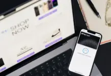 BuyWander Raises $21M to Expand Auction Marketplace for Returned and Overstocked Goods Laptop displaying an online shop with a prominent 'Shop Now' banner; a nearby iPhone shows Apple Pay Cash ready to pay
