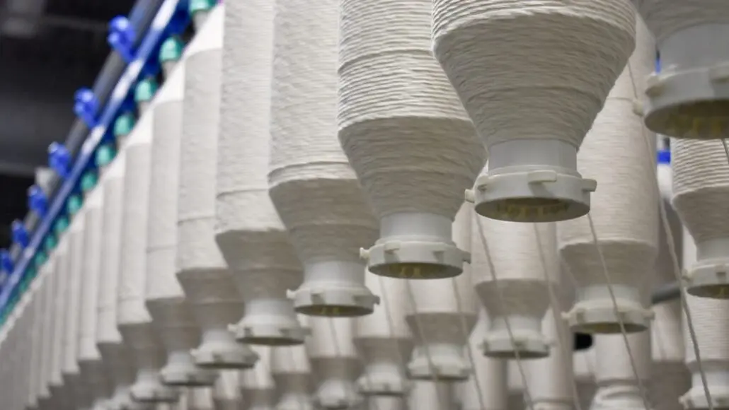 Row of white conical filter cartridges hanging in an industrial filtration system.]