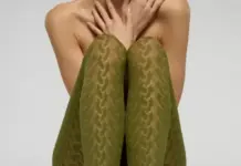 Oroblù Unveils Innovative Bio-Derived Sneakers Tights Collection Using Renewable Fibers Person seated with knees drawn up, wearing olive-green patterned tights; arms cover their chest and shoulders are bare.