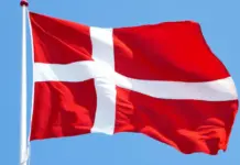 Denmark Unveils Three-Year Plan to Support Textile Sector’s Transition Danish flag waving on a white flagpole against a clear blue sky